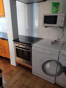 a kitchen with a washing machine and a microwave at Chalet Calan Bosch in Cala en Bosc
