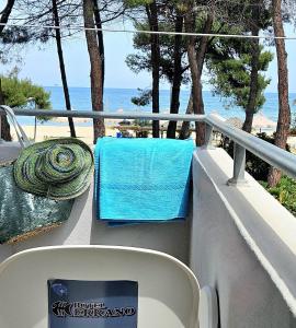 um banco com uma toalha azul numa varanda com vista para o oceano em Hotel Cerrano em Silvi Marina