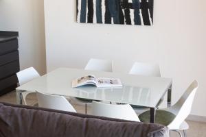 tavolo bianco da pranzo con sedie bianche e un libro sopra di Suite vista mare a Gaeta