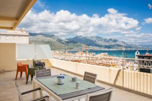 balcón con mesas y sillas y vistas al agua en Suite vista mare, en Gaeta