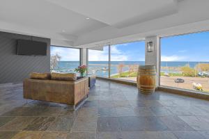 a living room with a couch and large windows at Ramada by Wyndham Jordan/Beacon Harbourside Resort in Jordan