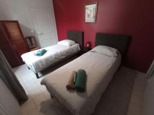 2 Betten in einem Zimmer mit roten Wänden in der Unterkunft Gite cosy 4 pers en vallée de la Creuse in Baraize