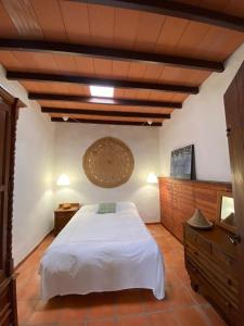 1 dormitorio con cama blanca y techo de madera en La Cuesta14, en Güime