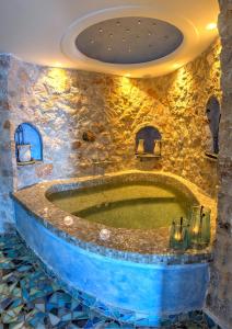 a jacuzzi tub in a room with a stone wall at Astarte Suites in Akrotiri