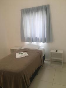 a bedroom with a bed and a window with a towel on it at Clip d´Oro Hotel in Camaçari