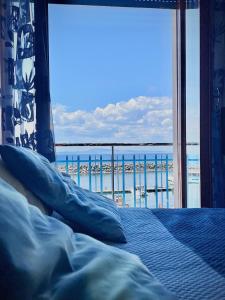 Schlafzimmer mit einem Bett und Strandblick in der Unterkunft Aqua Blu Apartment Stella Maris in Piano di Sorrento