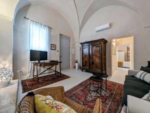 a living room with a couch and a tv and a table at La Casa di Marina in Muro Leccese