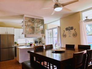 a kitchen with a dining table and a kitchen with a refrigerator at 3 BR Villa Tranquilidad in Vega Alta