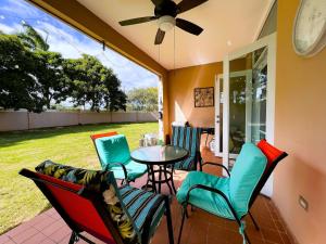 un porche cubierto con mesa y sillas en 3 BR Villa Tranquilidad, en Vega Alta