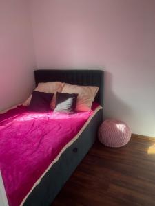 a bed with a pink blanket and pillows on it at Apartament 4You in Żywiec