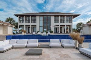una casa con piscina y muebles blancos delante de ella en The Bahamas Beachfront Dream Villa en Alice Town