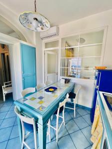 eine Küche mit einem blauen Tisch und weißen Stühlen in der Unterkunft Aqua Blu Apartment Stella Maris in Piano di Sorrento