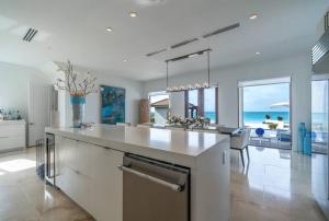 a kitchen with a large island with a view of the ocean at The Bahamas Beachfront Dream Villa in Alice Town