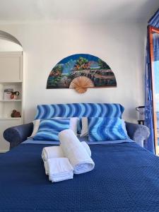 ein blaues Bett mit weißen Handtüchern darüber in der Unterkunft Aqua Blu Apartment Stella Maris in Piano di Sorrento