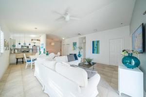 Bimini Blue Villa Villa في أليس تاون: غرفة معيشة بيضاء واثاث ابيض ومطبخ