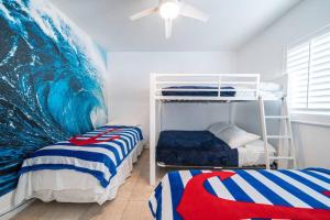 um quarto com 2 beliches e um mural de ondas em Bimini Blue Villa Villa em Alice Town