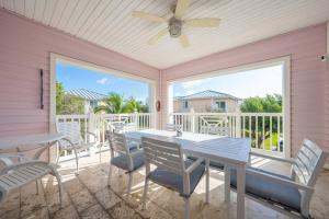 a porch with a table and chairs and a ceiling fan at Bimini Blue Villa Villa in Alice Town