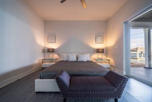 1 dormitorio con 1 cama con silla y ventana en Largest Private Island Home & Pool Villa, en Alice Town