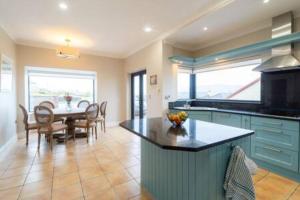 a kitchen with blue cabinets and a table with chairs at Duinin in Dingle