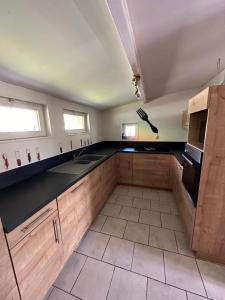 a kitchen with wooden cabinets and a black counter top at Camping De La Seine in Jumièges