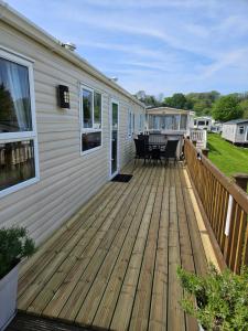 een houten terras met een tafel en stoelen op een huis bij 10 min walk to South Devon beach in Paignton