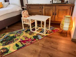 een kamer met een tafel en een stoel op een tapijt bij Exil Apartment in Sankt Englmar
