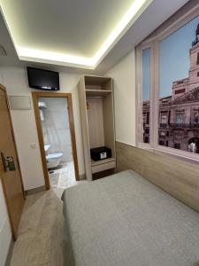 Postel nebo postele na pokoji v ubytování Hostal Castilla II Puerta del Sol
