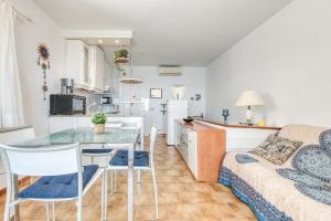 een keuken en een woonkamer met een tafel en stoelen bij Ibiza Bramer 11 Canyelles Roses - Barneda in Roses