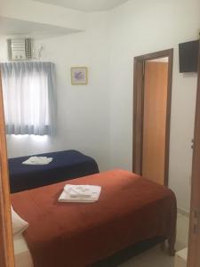 a hotel room with two beds and a mirror at Clip d´Oro Hotel in Camaçari