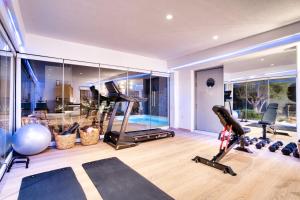 La Ponta Villas & Suites في أكروتيري: صالة ألعاب رياضية مع معدات ممارسة الرياضة في المنزل