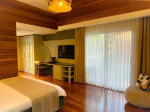 a bedroom with a bed and a desk and a television at Cirali Hera Hotel in Cıralı