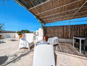 a group of white chairs and tables on a patio at La Casa di Marina in Muro Leccese