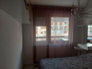 Dormitorio con ventana, cama y escritorio en Modern 1-bedroom condo, en Podgorica