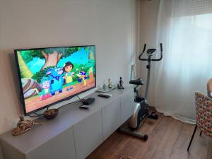 TV de pantalla plana en la parte superior de un armario blanco en Modern 1-bedroom condo, en Podgorica