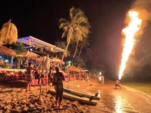un espectáculo de fuego en la playa por la noche en Stunning 1-Bed Chalet in El Pillax Resort ko lanta, en Phra Ae beach