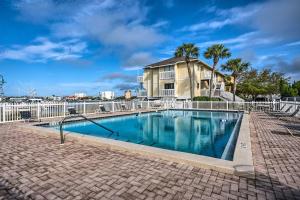 a swimming pool in front of a white fence at Destin Ground-Level Condo with Private Beach Access in Destin