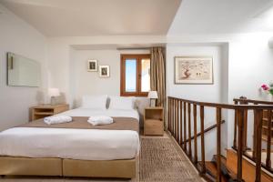 a bedroom with a large bed and a staircase at Rocca a Mare Maisonette I in Heraklio Town