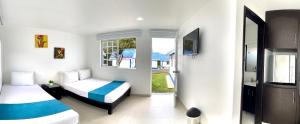 um quarto com duas camas e uma televisão em Hotel Villa Mónaco em Pereira