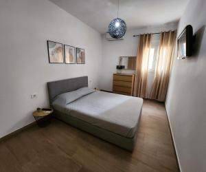 um pequeno quarto com uma cama e uma janela em Loft Apartment in Kos em Kefalos