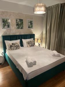a bedroom with a large bed with towels on it at Copou Central Linden Suite in Iaşi