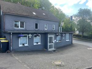 una casa azul con flores en las ventanas en Siegen Achenbach 4 en Siegen