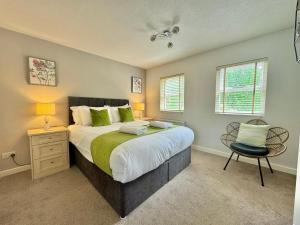 ein Schlafzimmer mit einem großen Bett und einem Stuhl in der Unterkunft Cherry Blossom Cottage in York