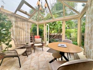 ein Orangerien-Wintergarten mit Tisch und Stühlen in der Unterkunft Cherry Blossom Cottage in York
