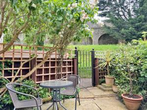 einen Tisch und Stühle in einem Garten mit einem Zaun in der Unterkunft Cherry Blossom Cottage in York
