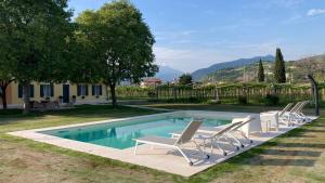 uma piscina com espreguiçadeiras ao lado de uma casa em B&B CAMPAGNON VALPOLICELLA em SantʼAmbrogio di Valpolicella