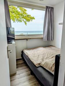 a bedroom with a bed and a large window at Panorama-Meerblick am Scharbeutzer Strand in Scharbeutz