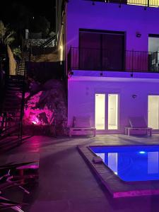 ein Haus mit einem Pool und violetten Lichtern in der Unterkunft Estudio nuevo zen in Calafell