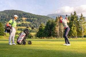 two people playing golf on a golf course at Apartment Bella Vista in Bad Kleinkirchheim