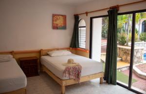 um quarto com uma cama com um chapéu em Vista Caribe Playa em Playa del Carmen