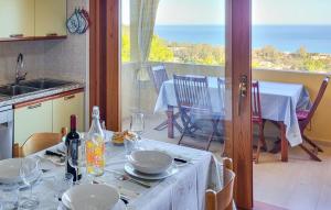a kitchen with a table with plates and wine glasses at Villetta Mare e Sole - vista mare, giardino privato, vicino spiaggia in Costa Rei